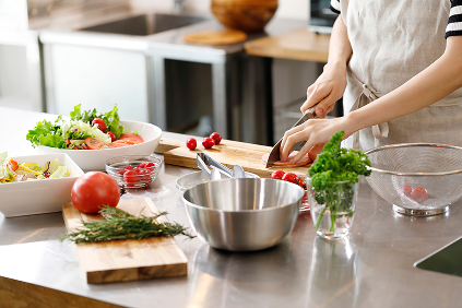 キッチンで野菜を切って料理をしている様子