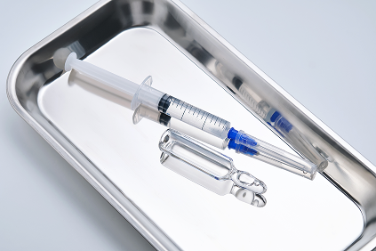 注射器とアンプルが金属トレーの上に並べられている様子