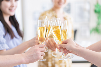 グラスを持った人たちが飲み物で乾杯している様子